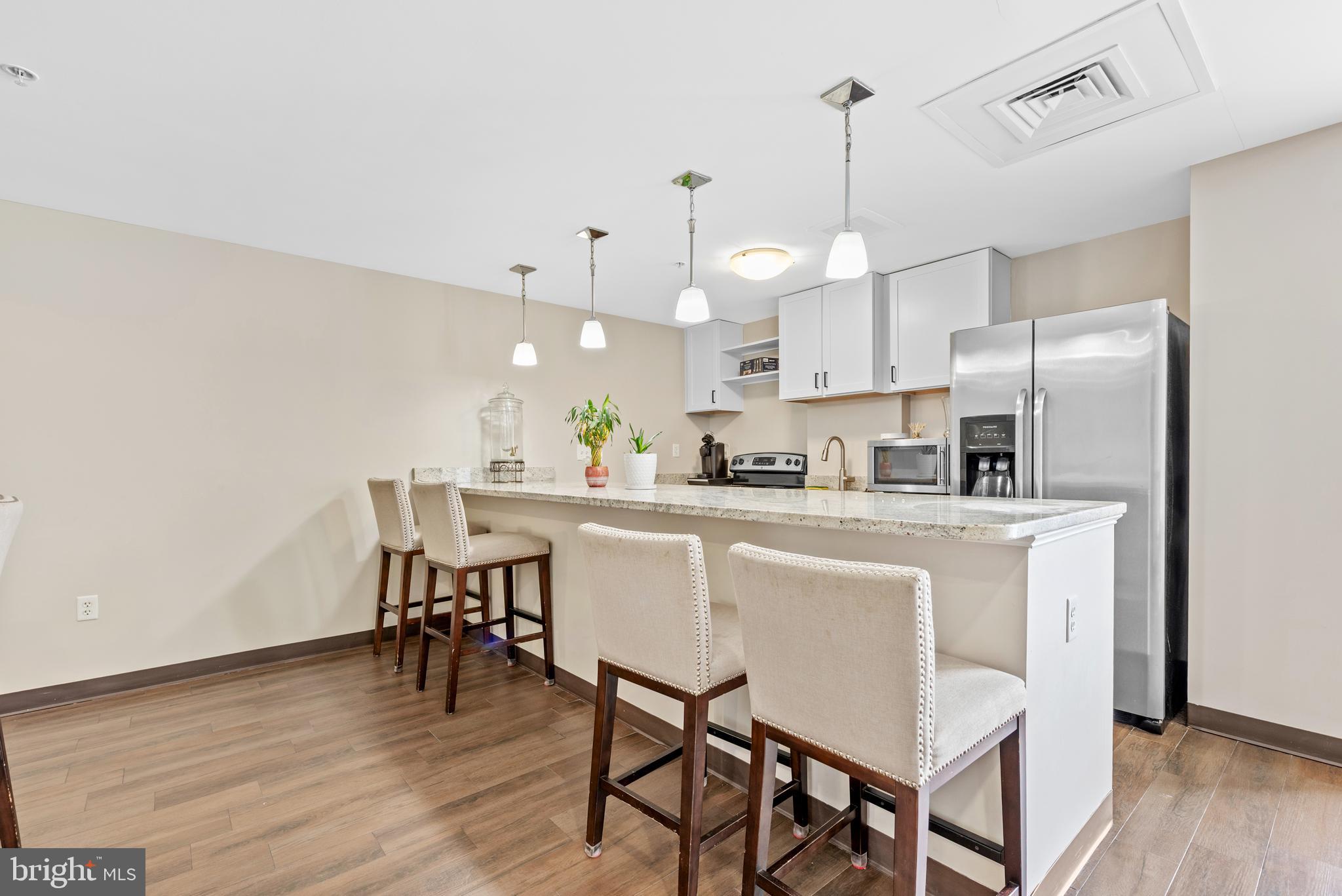 6301 Edsall Road, Unit 424 Alexandria, VA 22312 - Photo 28 of 30 a kitchen with kitchen island a dining table and chairs