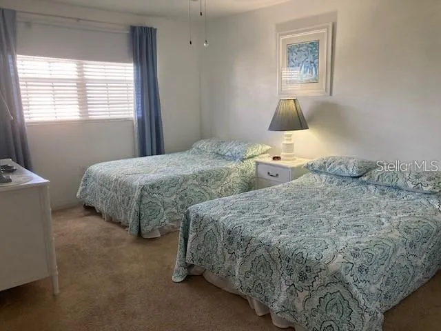 a bedroom with two beds and painting on the wall