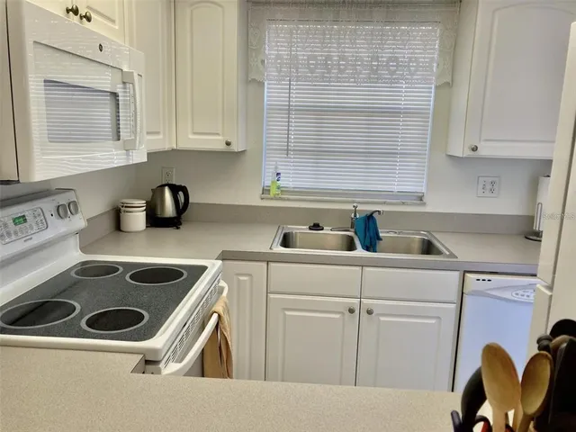 a kitchen with a sink a stove and cabinets