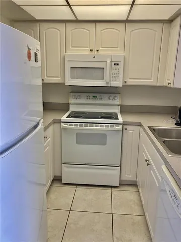 a stove top oven sitting inside of a kitchen with white cabinets