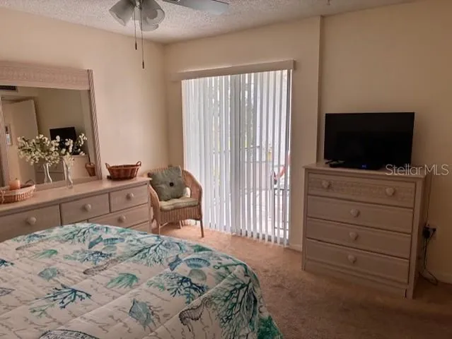 a bedroom with a bed and a flat tv screen on dresser