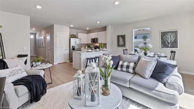 a living room with furniture kitchen view and a chandelier