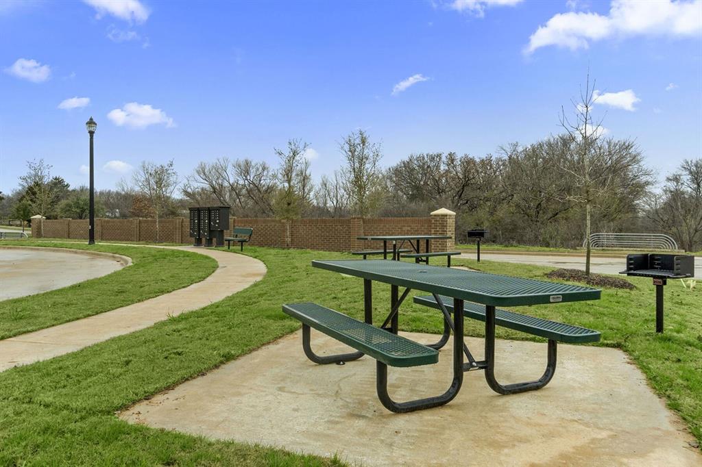3344 Duncan Way Corinth, TX 76210 - Photo 34 of 38 Outdoor picnic area featuring multiple green metal picnic tables on concrete pads