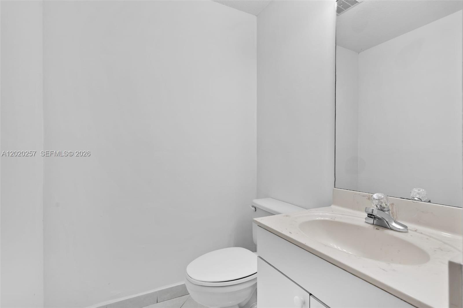 10245 Southwest 154th Place, Unit 1123 Miami, FL 33196 - Photo 9 of 38 a bathroom with a sink a toilet and mirror