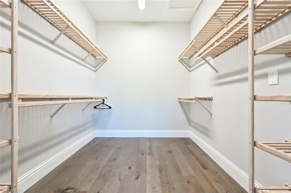 a view of walk in closet with wooden floor