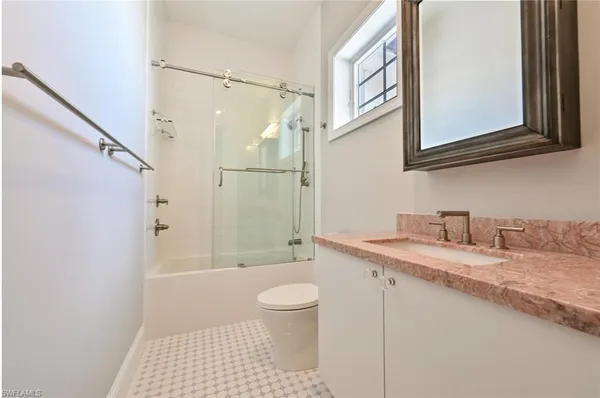 a bathroom with a granite countertop sink toilet and shower