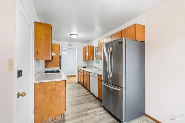 a kitchen with stainless steel appliances granite countertop a refrigerator and a stove