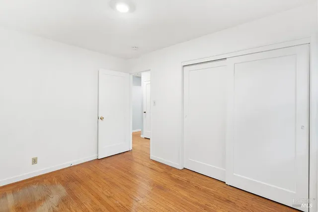 a view of an empty room with wooden floor