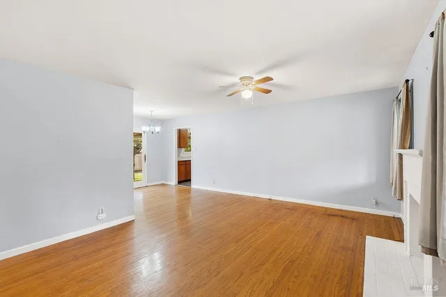 an empty room with wooden floor and window