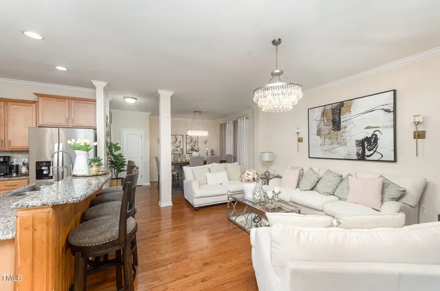 a kitchen with stainless steel appliances kitchen island granite countertop a stove a kitchen island a dining table and chairs with wooden floor