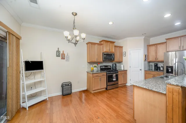 a living room with fireplace furniture and a kitchen view