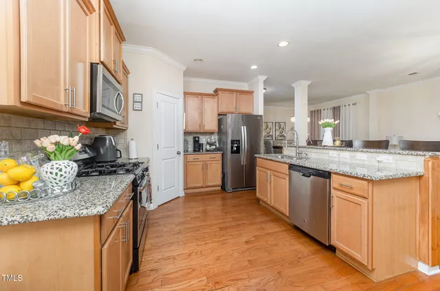a kitchen with granite countertop stainless steel appliances and wooden floor