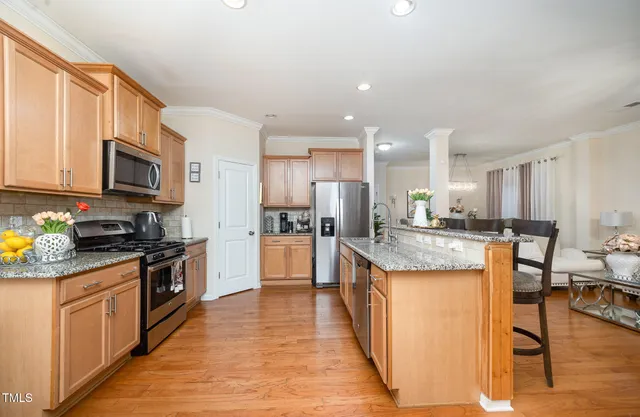 a kitchen with stainless steel appliances granite countertop a sink stove and refrigerator