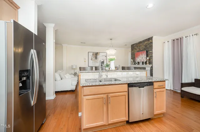 a kitchen with stainless steel appliances granite countertop a stove top oven a sink dishwasher and a refrigerator