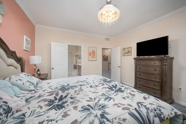 a bedroom with a bed a dresser and potted plants on the dresser
