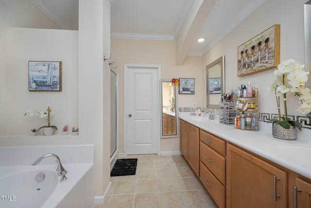 a bathroom with double vanity sinks a mirror and a bathtub