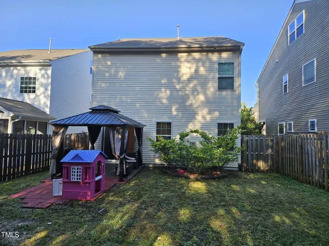 a view of a yard with plants and a table