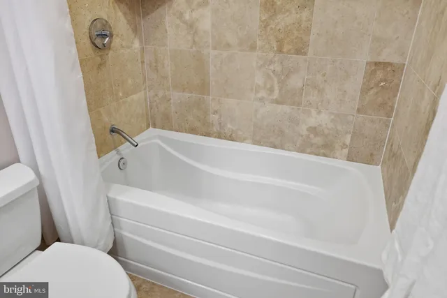 a kitchen with stainless steel appliances kitchen island granite countertop a table chairs refrigerator and microwave