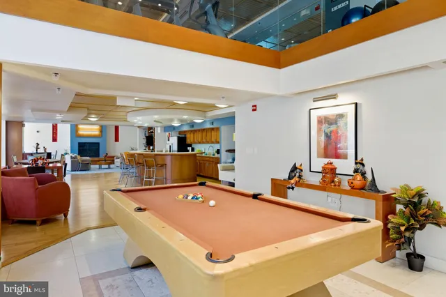 a room with stainless steel appliances lots of white furniture a dining table chairs and view living room