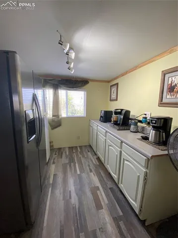 a kitchen with cabinets and wooden floor