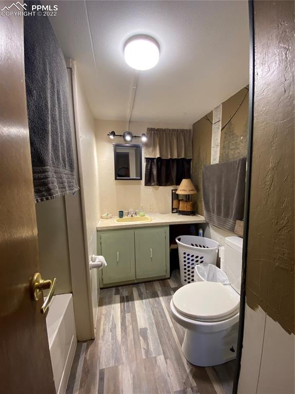 33895 East Jones Road Yoder, CO 80864 - Photo 24 of 45 a bathroom with a toilet a sink a mirror and vanity