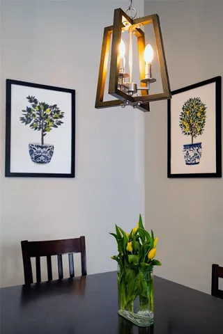 a vase with flowers on a table with a potted plant