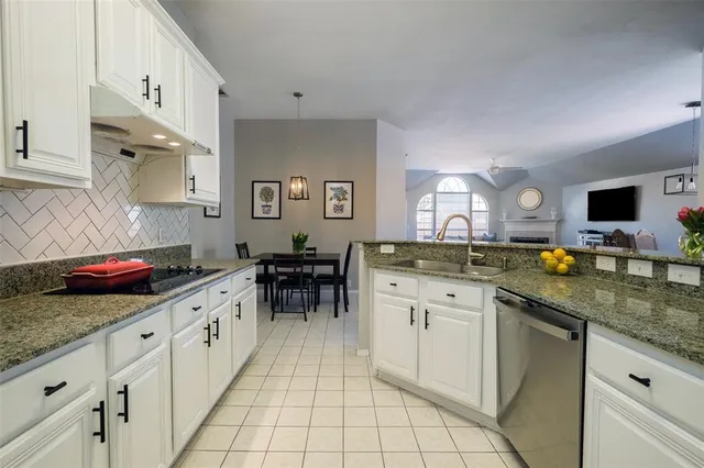 a kitchen with stainless steel appliances granite countertop a sink and a stove