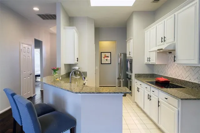 a kitchen with stainless steel appliances granite countertop a sink and cabinets