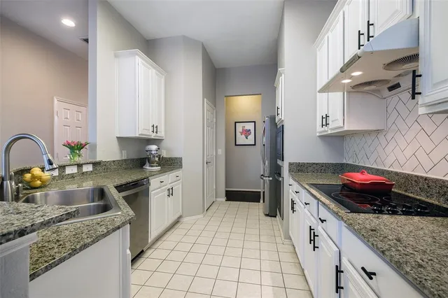 a kitchen with stainless steel appliances granite countertop a sink stove and cabinets