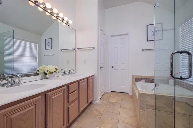 a spacious bathroom with a double vanity sink a large mirror and shower