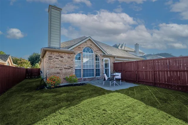 a view of a chair and table in backyard of the house