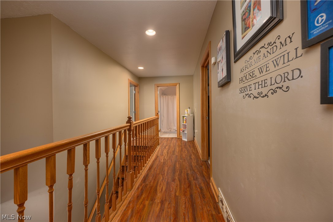 806 Forrest Ridge Drive Dover, OH 44622 - Photo 21 of 36 Hallway featuring dark wood-type flooring, recessed lighting, and an upstairs landing