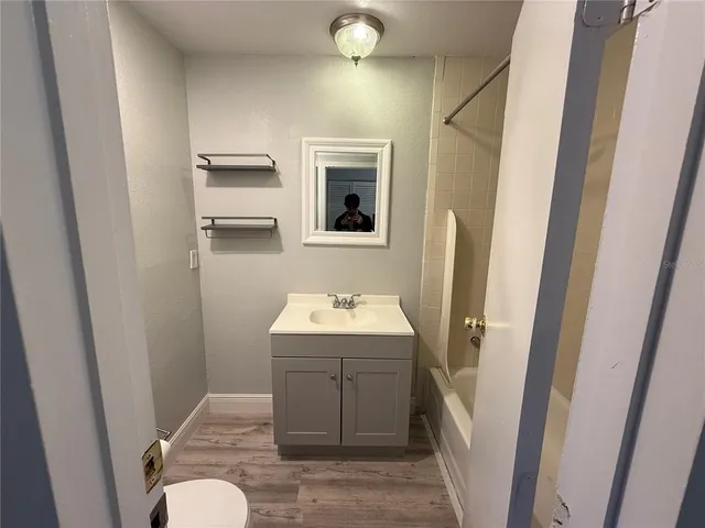 a bathroom with a sink and mirror with toilet
