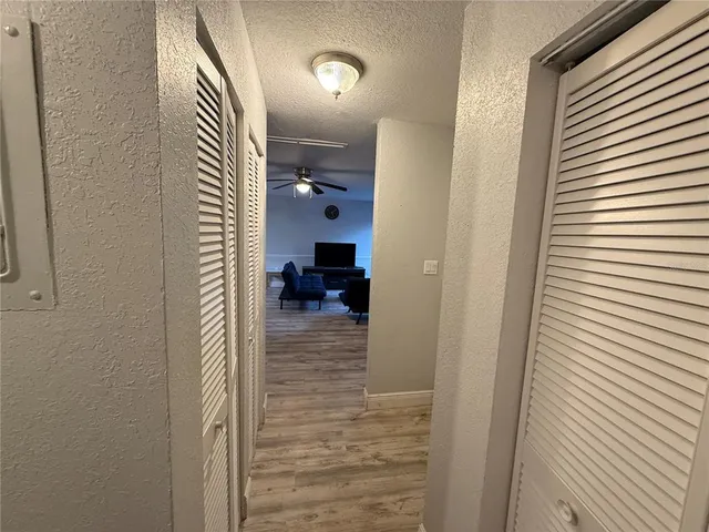 a view of a hallway with a door and a bathroom