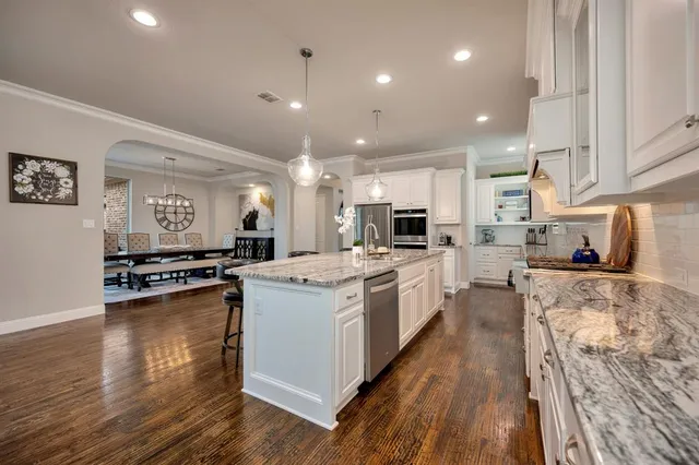 a large kitchen with stainless steel appliances and a large counter top