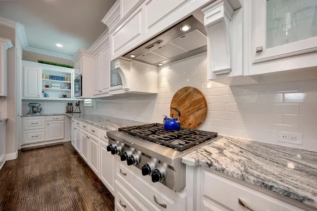 a kitchen with stainless steel appliances granite countertop a stove a sink and a microwave