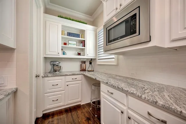 a kitchen with granite countertop white cabinets and white appliances