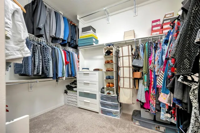 a view of walk in closet with clothes and shoes
