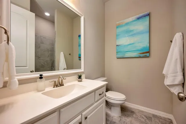 a bathroom with a toilet sink and mirror