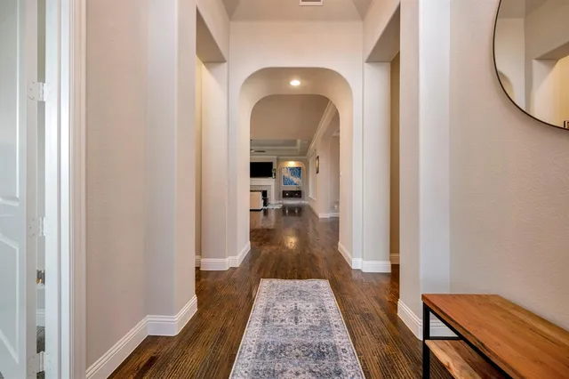 a view of a hallway with wooden floor and a living room