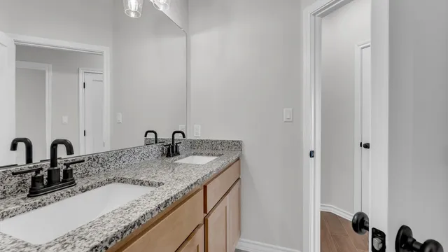 an empty room with wooden floor chandelier and windows