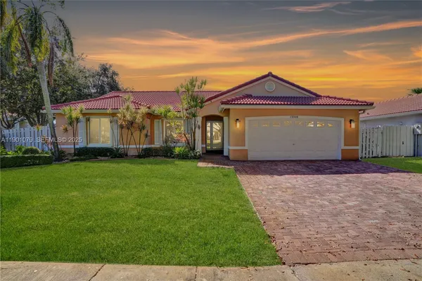 a front view of a house with a garden and yard