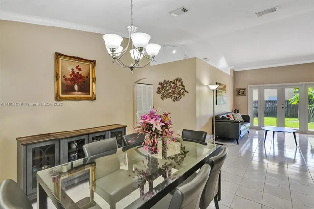 a view of a dining room with furniture a chandelier and wooden floor