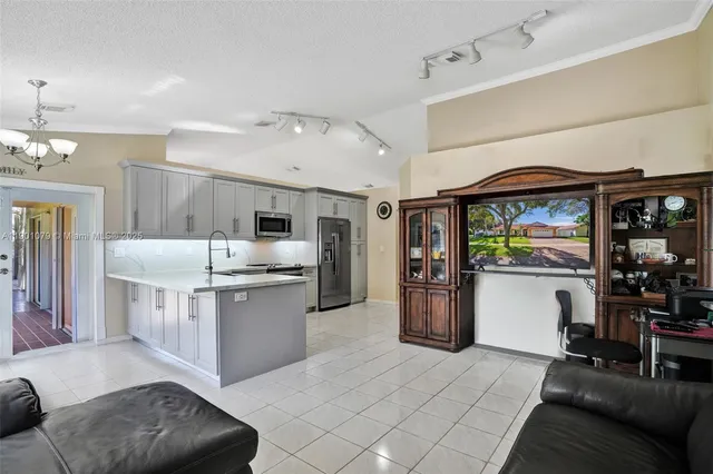 a kitchen with stainless steel appliances kitchen island granite countertop a refrigerator and stove