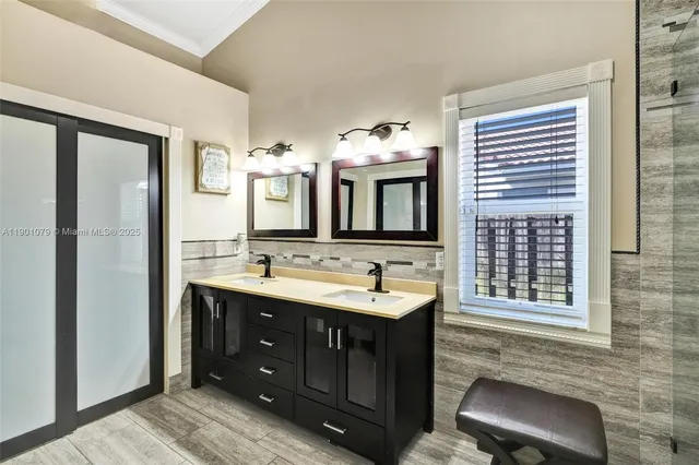 a spacious bathroom with a double vanity sink a large mirror and a bathtub