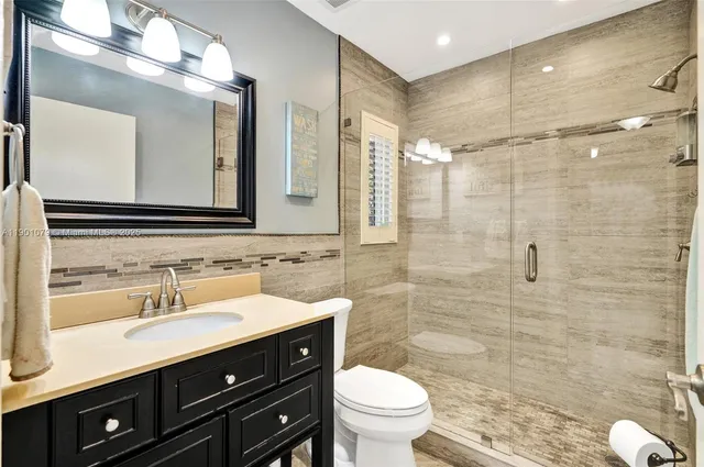 a bathroom with a double vanity sink mirror and toilet