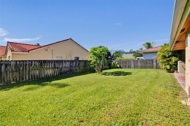a view of a house with backyard and sitting area