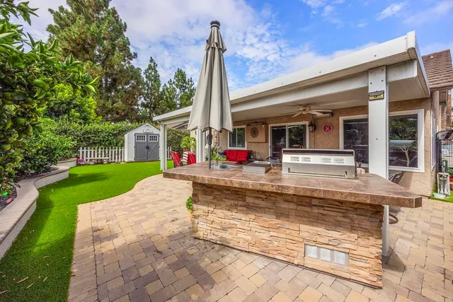 a view of house with swimming pool outdoor seating and house in the background