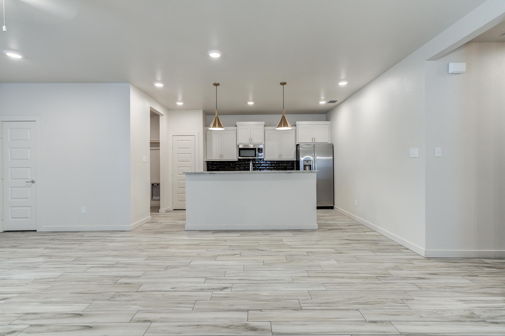 1121 North 7th Street Wolfforth, TX 79382 - Photo 6 of 25 a view of a kitchen with kitchen island microwave and cabinets