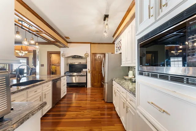 a kitchen with stainless steel appliances granite countertop a sink refrigerator and cabinets